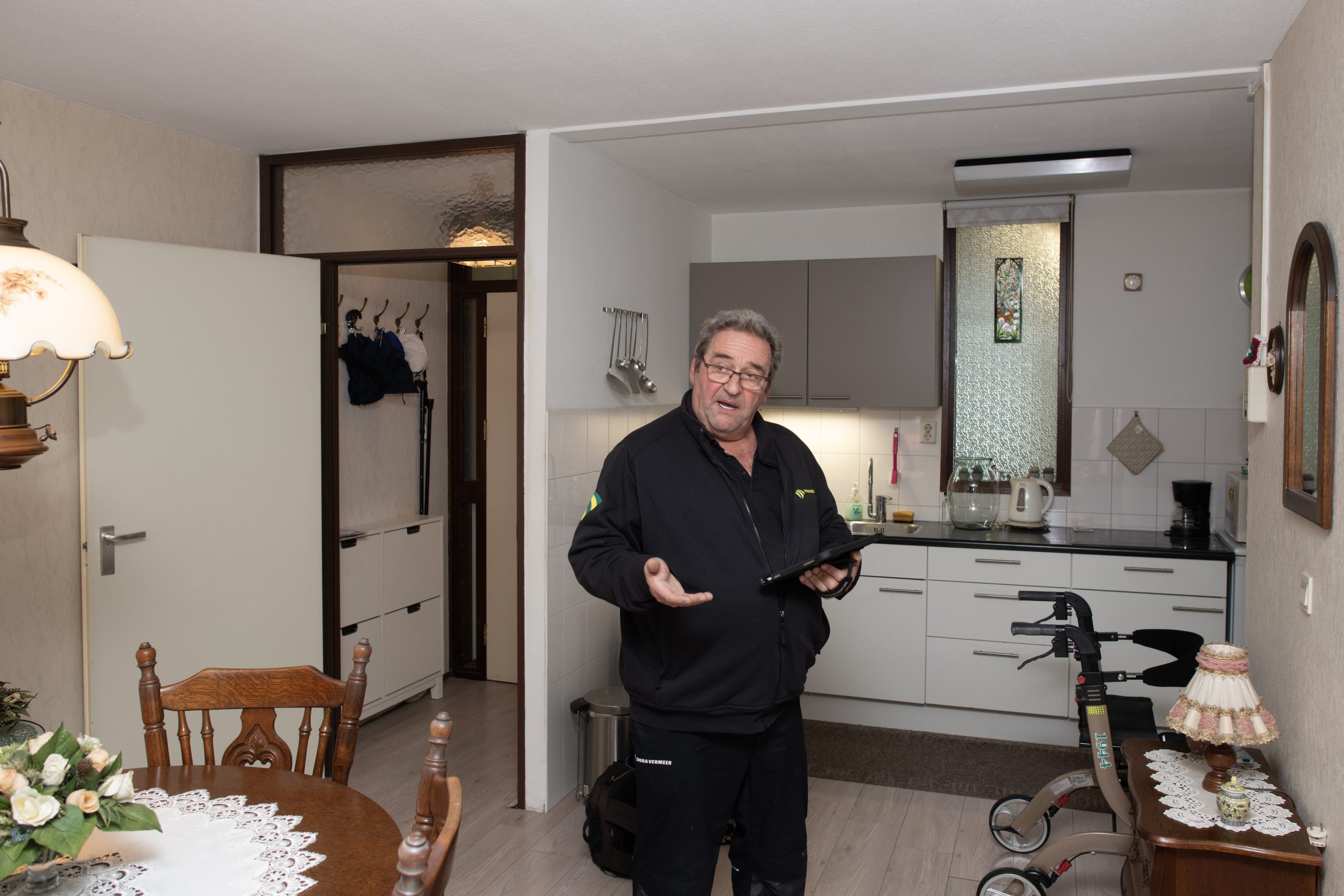 Uitvoerder legt aan bewoners uit wat hij doet bij de warme opname. Foto: Rufus de Vries